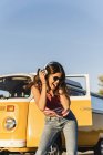 Hübsche Frau auf einem Roadtrip mit ihrem Wohnmobil, tanzen, Musik hören — Stockfoto