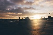 Helicopter on landing place during sunset — Stock Photo