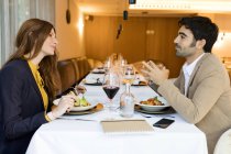 Smiling man and woman eating in a restaurant — Stock Photo