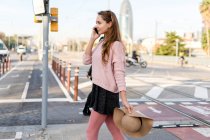 Giovane donna pendolare in città, parlando al telefono — Foto stock