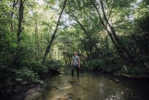 Молодой человек рыбачит в лесу — стоковое фото