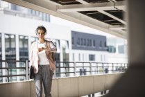 Young businesswoman walking in parking garage, checking time — Stock Photo