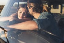 Romantic couple sitting in their camper with arms around — Stock Photo