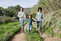 Happy family running in the countryside, holding hands — Stock Photo