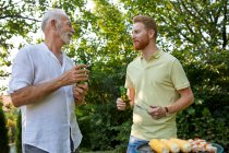 Senior father and adult son having a barbecue and talking in garden — Stock Photo