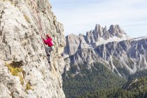 Italy, Cortina d'Ampezzo, woman climbing in the Dolomites mountains — Stock Photo