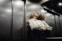 Femme d'affaires épuisée dans l'ascenseur — Photo de stock