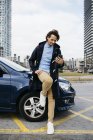 Spain, Barcelona, man using cell phone outside car in the city — Stock Photo