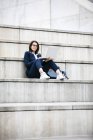 Портрет деловой женщины, сидящей на улице на лестнице с помощью ноутбука — стоковое фото