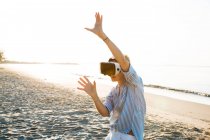 Thailand, woman using virtual reality glasses on the beach in the morning light — Stock Photo