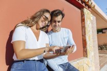 Счастливая пара смотрит на сотовый телефон в солнечный день — стоковое фото