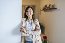 Selbstbewusste Frau lehnt mit verschränkten Armen an Wand, Porträt — Stockfoto