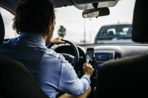 Geschäftsmann fährt Auto mit Handy als Navigationssystem — Stockfoto