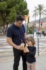 Father and son with soft drinks in the city — Stock Photo
