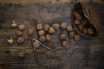 Плетеная корзина, целые и потрескавшиеся грецкие орехи и орехи на дереве — стоковое фото
