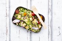 Lunch box of zoodles with fried tofu, red quinoa, red onions and tomatoes — Stock Photo
