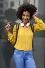 Retrato de mujer riendo con mochila y auriculares - foto de stock