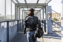 Rear view of young woman walking on a bridge — Stock Photo