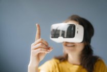 Женщина в виртуальных очках, наблюдает за поднятым пальцем — стоковое фото