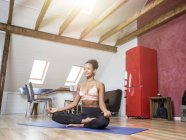 Souriant jeune femme pratiquant le yoga — Photo de stock