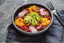 Insalata di quinoa rossa con avocado, pomodori, ravanelli rossi, semi di melograno, sesamo nero e crescione — Foto stock