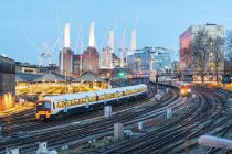 Сполучене Королівство, Англія, Лондон, вид залізничних трас і потягів увечері, колишня електростанція та крани у фоновому режимі — Stock Photo