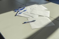 Papeles en blanco y bolígrafos en un escritorio, de cerca - foto de stock