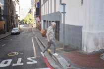 Зрілий чоловік ходить по місту, несучи сумку — стокове фото
