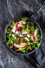 Bowl of mixed salad with lamb's lettuce, feta, pear, pomegranate seed and walnuts — Stock Photo