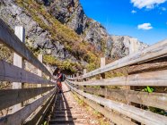 Spain, Asturia, Cantabrian Mountains, senior man on a hiking trip standing on a bridge — Stock Photo