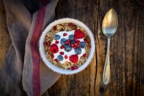 Ciotola di muesli con yogurt greco, quinoa schioccata, lamponi, mirtilli e semi di melograno, dall'alto — Foto stock