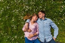 Feliz pareja joven relajándose en la hierba en un parque, vista aérea - foto de stock