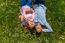 Feliz pareja joven relajándose en la hierba en un parque, vista aérea - foto de stock
