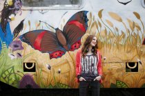 Sorridente ragazza adolescente in piedi a un treno dipinto auto — Foto stock