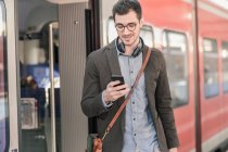 Junger Mann benutzt Handy in S-Bahn — Stockfoto