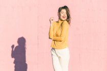 Giovane donna felice davanti a un muro rosa — Foto stock