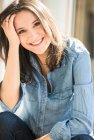 Портрет счастливой женщины в джинсовой рубашке дома — стоковое фото