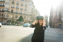 Захоплена жінка в окулярах VR в місті — стокове фото