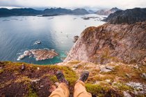 Норвегия, Лофотенские острова, Хеннингсваер, турист, сидящий на смотровой площадке — стоковое фото