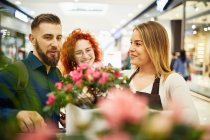 Verkäuferin berät Paar im Blumenladen — Stockfoto