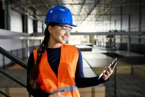 Smiling female worker using tablet in factory warehouse — Stock Photo