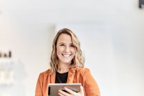 Portrait de jeune femme d'affaires souriante avec mini tablette — Photo de stock
