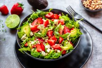 Strawberry avocado salad with feta, rocket, pine nuts and cress — Stock Photo