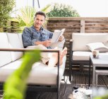 Hombre seguro de relajarse en la terraza, libro de lectura - foto de stock