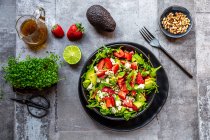 Strawberry avocado salad with feta, rocket, pine nuts and cress — Stock Photo