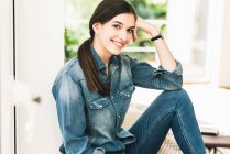 Портрет улыбающейся девушки в джинсовой рубашке дома — стоковое фото