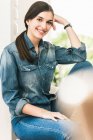Портрет улыбающейся девушки в джинсовой рубашке дома — стоковое фото