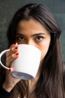 Jeune femme dans un café avec une tasse de café — Photo de stock