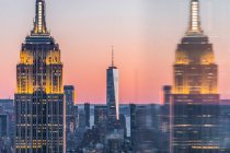 Skyline au coucher du soleil avec Empire State Building au premier plan et One World Trade Center en arrière-plan, Manhattan, New York, États-Unis — Photo de stock