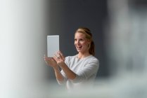 Feliz joven mujer sosteniendo tableta - foto de stock